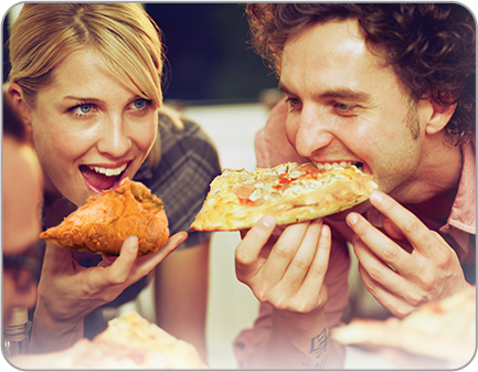Two people eating chicken and pizza